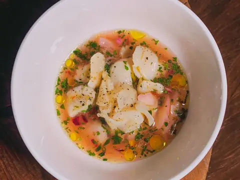 Ceviche de pescado con cebolla morada y culantro en un tazón.