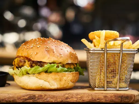 Hamburguesa con queso y canasta de papas fritas.
