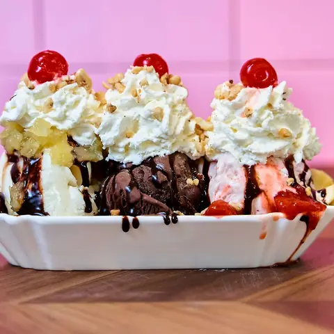 Banana split con crema batida, chocolate y cerezas.